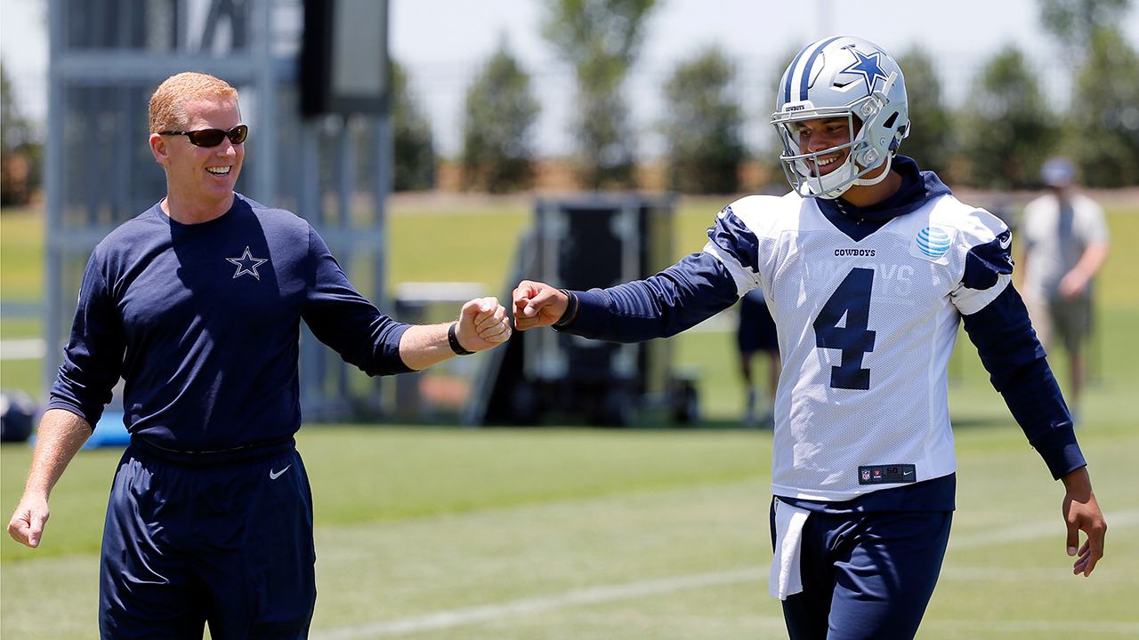 Dallas Cowboys head coach Jason Garrett, left, gets quarterback Dak Prescott (4) a fist bump as the two walk off the field after an NFL football organized team activities practice at the team's training facility, Wednesday, May 24, 2017, in Frisco, Texas. (AP Photo/Tony Gutierrez)