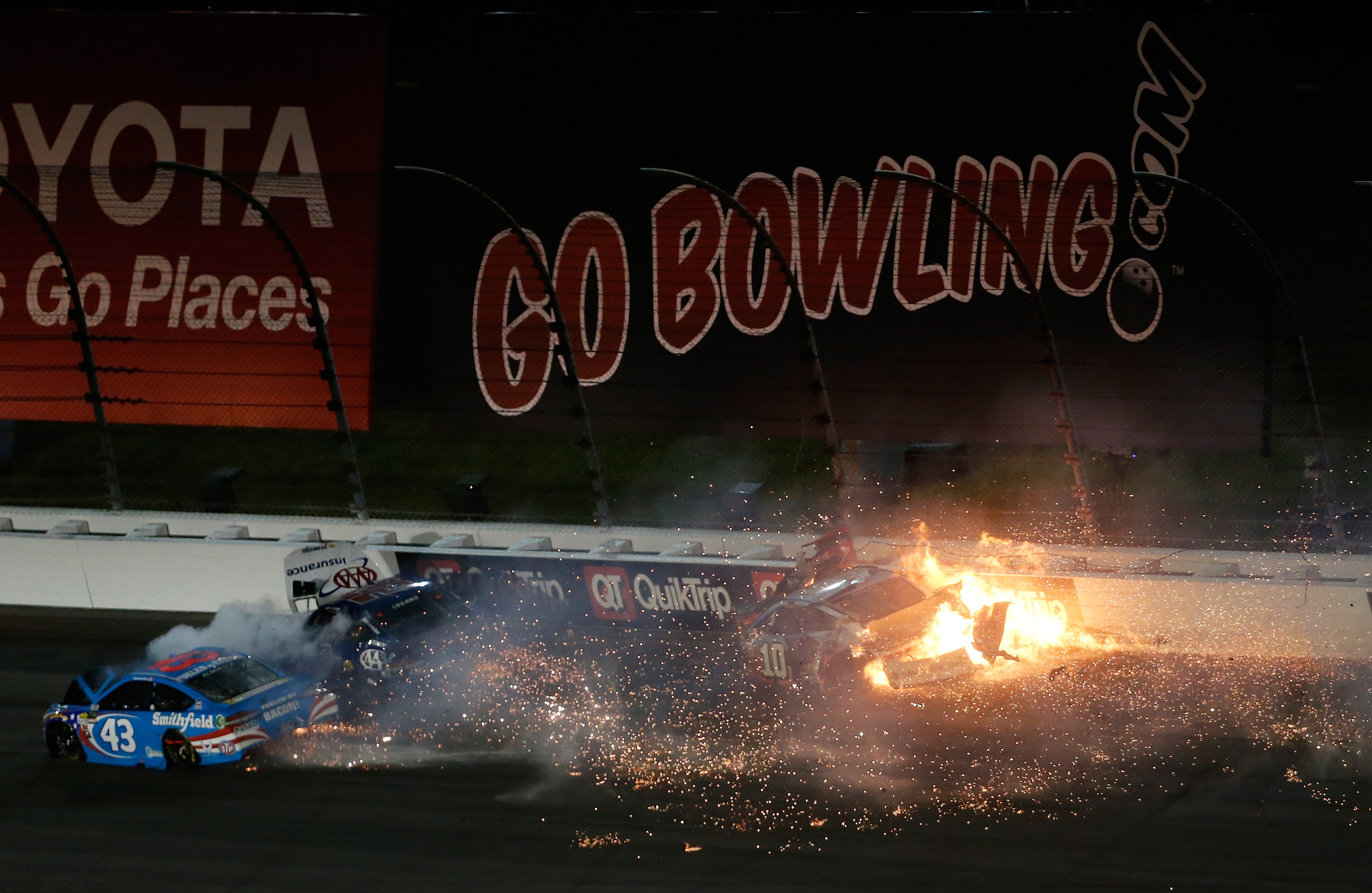 KANSAS CITY, KS - MAY 13:  Joey Logano, driver of the #22 AAA Insurance Ford, Danica Patrick, driver of the #10 Wonder Woman/One Cure Ford, and Aric Almirola, driver of the #43 Smithfield Ford, crash during the Monster Energy NASCAR Cup Series Go Bowling 400 at Kansas Speedway on May 13, 2017 in Kansas City, Kansas.  (Photo by Sean Gardner/Getty Images)